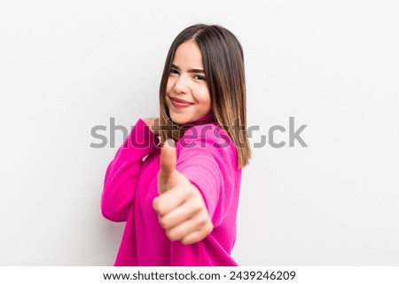 pretty hispanic woman feeling proud, carefree, confident and happy, smiling positively with thumbs up
