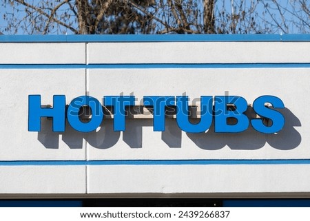 Hot tubs big blue signage on the fasade of shop which sells jacuzzis, fire pits, patio heaters etc.