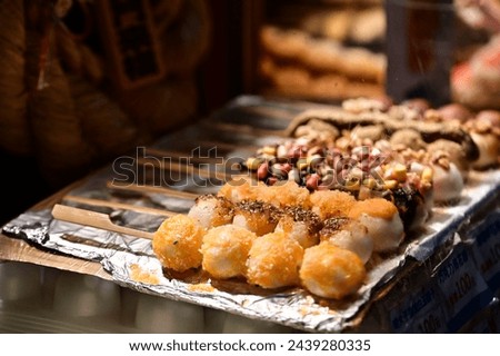 Dango are chewy Japanese sweet dumplings made from rice flour. These bite-sized treats come in a variety of flavors, including savory-sweet soy sauce glaze, red bean paste, and toasted soybean flour. Royalty-Free Stock Photo #2439280335