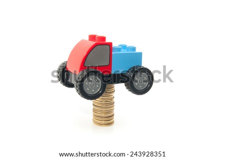 Toy car and stack of gold coins isolated on white background