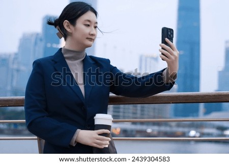 Young Professional Capturing Selfie on Urban Backdrop