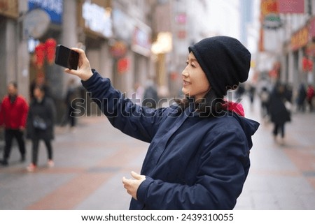 Young Woman Capturing Selfie on Busy City Street