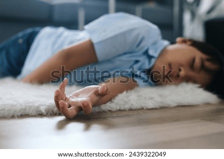 Little boy lying on the floor at home. Healthcare and medical concept. Royalty-Free Stock Photo #2439322049