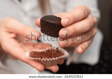 Hands Holding Chocolate Muffins. Presenting freshly baked chocolate muffins