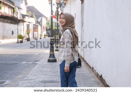 happy asian muslim woman roaming around kota lama or old city area, Semarang, Central Java , Indonesia. Traveling concept