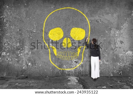 Woman painting skull on wall