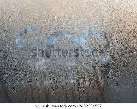 The word sos is written on the wet glass of the window.