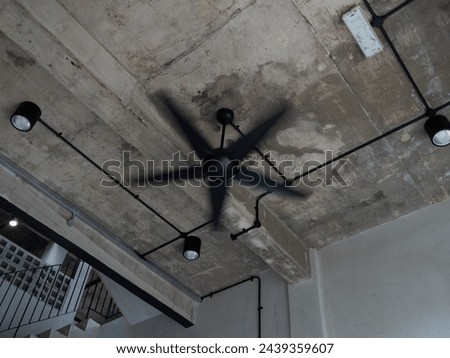 Fan matte black colour spinning on concrete ceiling