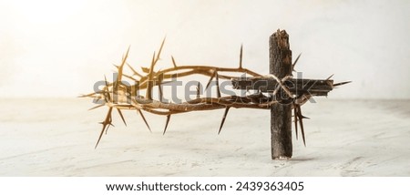 Wooden cross and crown of thorns on light background. Good Friday concept