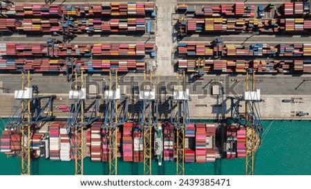 Container ship docked load and unloading goods of international import export, crane lifting containers from ships to trailers for distribution to consumers and industrail companies, aerial top view Royalty-Free Stock Photo #2439385471