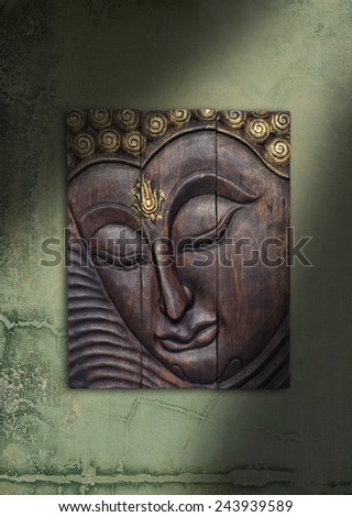 Buddha image in Thai style wood graving on the wall