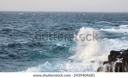 The waves crashing coolly in the blue sea seem to be refreshing themselves. Royalty-Free Stock Photo #2439404681