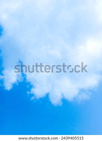 A serene blue sky adorned with fluffy clouds, offering a sense of tranquility and expansiveness.

