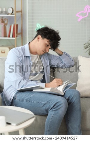 Tired male student studying at home