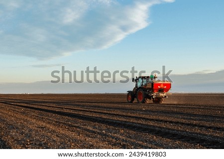 Tractor spreading artificial fertilizers. Transport, agricultural. Royalty-Free Stock Photo #2439419803