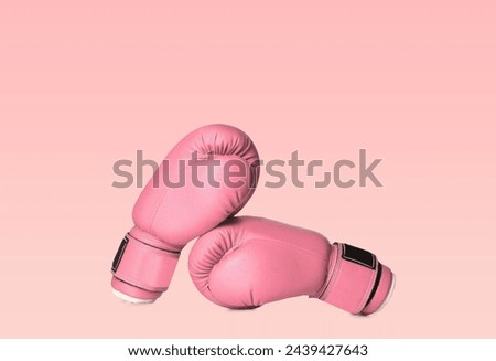 Breast cancer. Pair of pink boxing gloves on color background Royalty-Free Stock Photo #2439427643