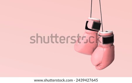 Fight against breast cancer. Pair of pink boxing gloves on color background, space for text. Banner design Royalty-Free Stock Photo #2439427645