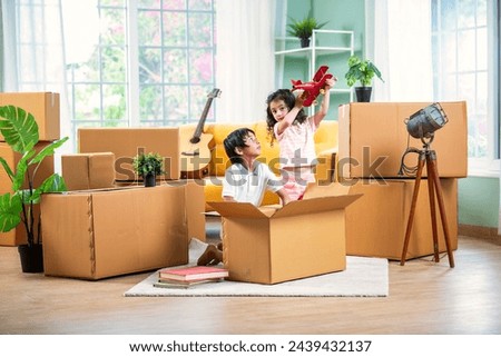 Curious Indian asian children unboxing carton on moving or shifting day Royalty-Free Stock Photo #2439432137