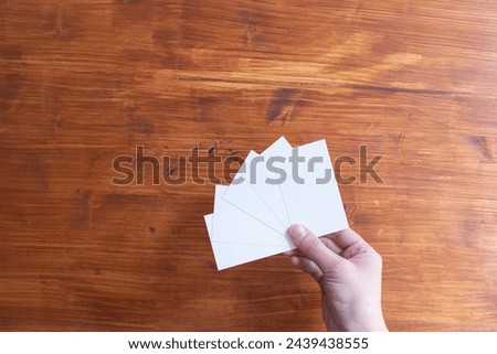 person's hand holding a white card