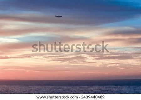 Plane in sky is landing. Beautiful sunset in sky with clouds and rays of sun