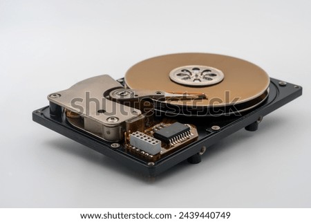 HDD, Hard disk drive, platters, circular magnetic disk. Mechanical and electronic components. Actuator arm with read write head. Central spindle. Circuit board. Precision device for data storage.