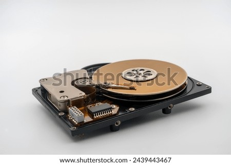 HDD, Hard disk drive, platters, circular magnetic disk. Actuator arm with read write head. Central spindle. Circuit board. Mechanical and electronic components. Precision device for data storage.