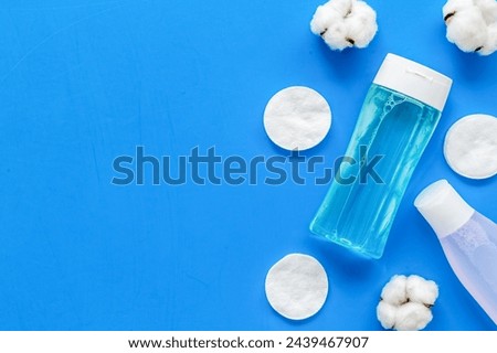 skin care organic cosmetics with facial tonic bottle, mycelial water bottle and cotton pads on blue desk background top view mockup Royalty-Free Stock Photo #2439467907