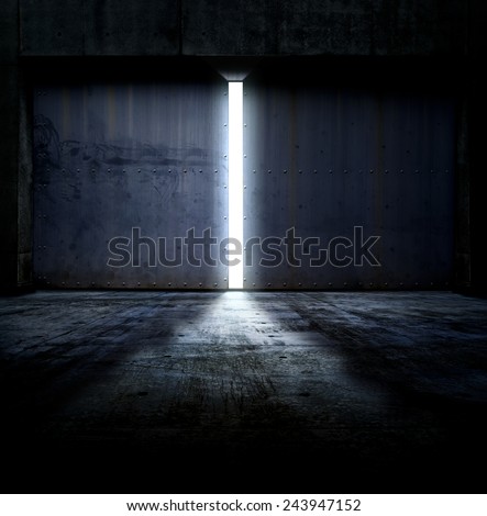 Heavy steel doors opening. Large steel doors of an hanger like building opening and light coming in. Royalty-Free Stock Photo #243947152