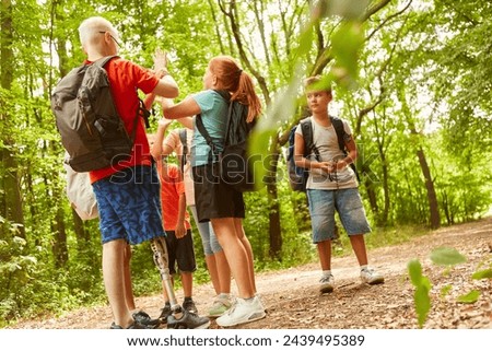 Full length picture of boy with prosthetic leg playing games with friends at forest