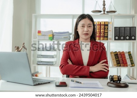 Asian female lawyer working in office or court with hammer and justice pad on table, online legal advice with new laws of real estate business. Law, legal service, advice, justice.