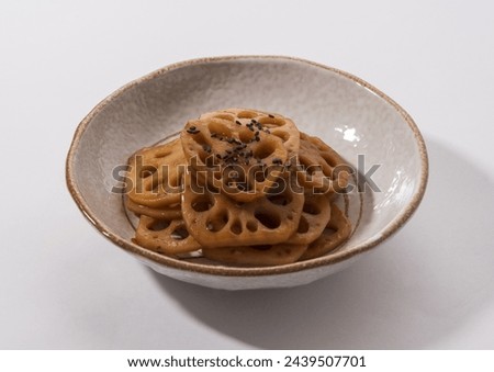 Close-up of stewed lotus roots with seasoning and black sesame seeds on dish and white floor, South Korea
 Royalty-Free Stock Photo #2439507701