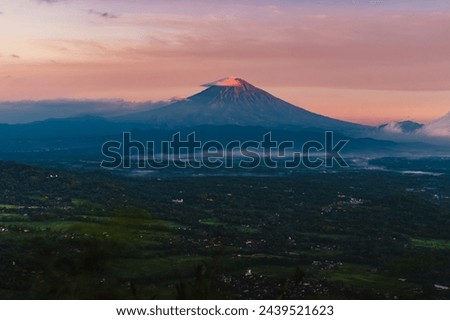 a view of the Sumbing mountain on a clear morning with light mist below. A peaceful morning in a highland area. Photo for a background with a natural feel. 