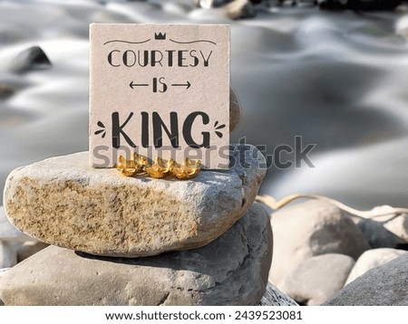 Inspirational Quote - courtesy is king on paper with nature background. Stock photo.