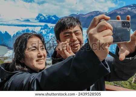 mother and son taking photo with cell phone in a mountainous place