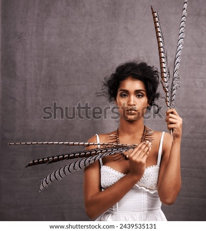 Fashion, studio and portrait of boho woman with feather, mockup and modern Native American style. Creative, culture and girl with indigenous aesthetic, serious or unique face on grey background space