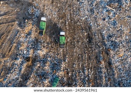 Aerial view of garbage truck unload pile of waste at landfill with cows. Dump of unsorted waste garbage pile in trash dump. Environmental pollution and ecological disaster. View from drone Royalty-Free Stock Photo #2439561961