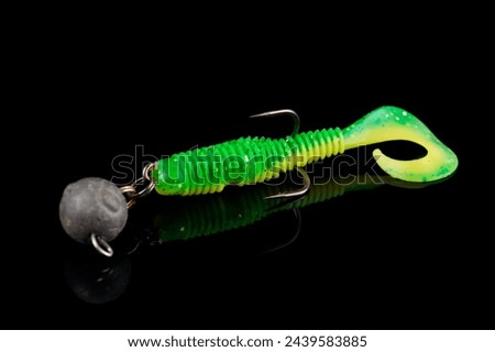 Soft fishing bait, green plastic grub, with double hook and lead sinker, isolated on black background Royalty-Free Stock Photo #2439583885