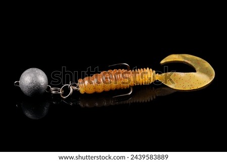Soft fishing bait, silicone grub, with double hook and lead sinker, isolated on black background Royalty-Free Stock Photo #2439583889