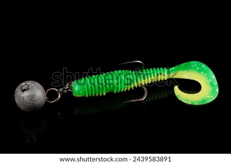 Soft fishing bait, green plastic grub, with double hook and lead sinker, isolated on black background Royalty-Free Stock Photo #2439583891