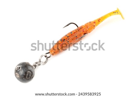 Orange fishing lure, plastic shad fish, with double hook and lead sinker, isolated on white background Royalty-Free Stock Photo #2439583925
