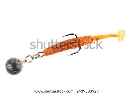 Orange fishing lure, plastic shad fish, with double hook and lead sinker, isolated on white background Royalty-Free Stock Photo #2439583929