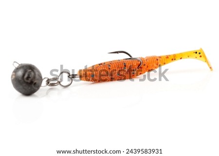 Orange fishing lure, plastic shad fish, with double hook and lead sinker, isolated on white background Royalty-Free Stock Photo #2439583931