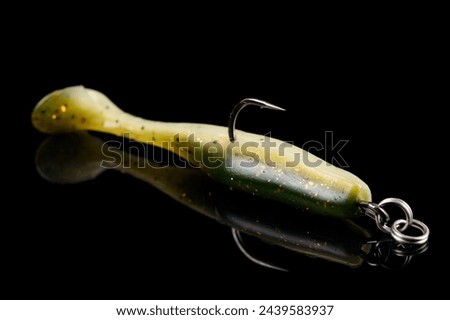 Orange fishing lure, plastic shad fish, with double hook, isolated on black background Royalty-Free Stock Photo #2439583937