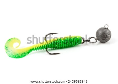 Soft fishing bait for predatory fish, green plastic grub, with double hook and lead sinker, isolated on background Royalty-Free Stock Photo #2439583943