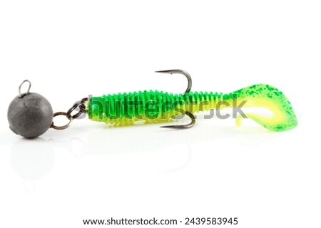 Soft fishing bait for predatory fish, green plastic grub, with double hook and lead sinker, isolated on background Royalty-Free Stock Photo #2439583945