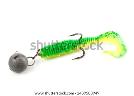 Soft fishing bait for predatory fish, green plastic grub, with double hook and lead sinker, isolated on background Royalty-Free Stock Photo #2439583949