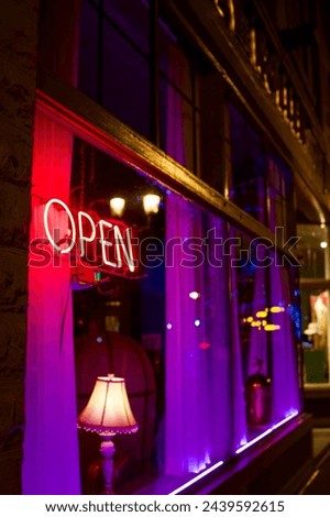 Neon open sign, nightlife through the window, colourful lights in the evening