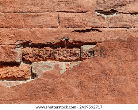 Red brick wall of an old building with crumbling plaster. Copy space. Selective focus. Royalty-Free Stock Photo #2439592717