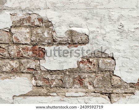 Dirty brick wall of an old building with crumbling plaster. Copy space. Selective focus. Royalty-Free Stock Photo #2439592719