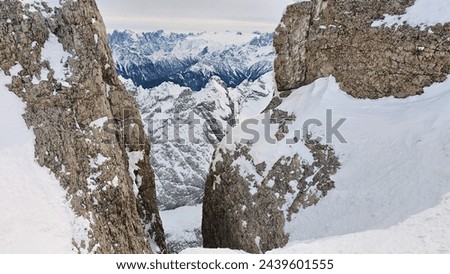 Dolomites mountain view between rocks on top of Marmolada Glacier (Ghiacciaio della Marmolada) in Trentino, Italy. Panorama view after heavy snowfall. 
